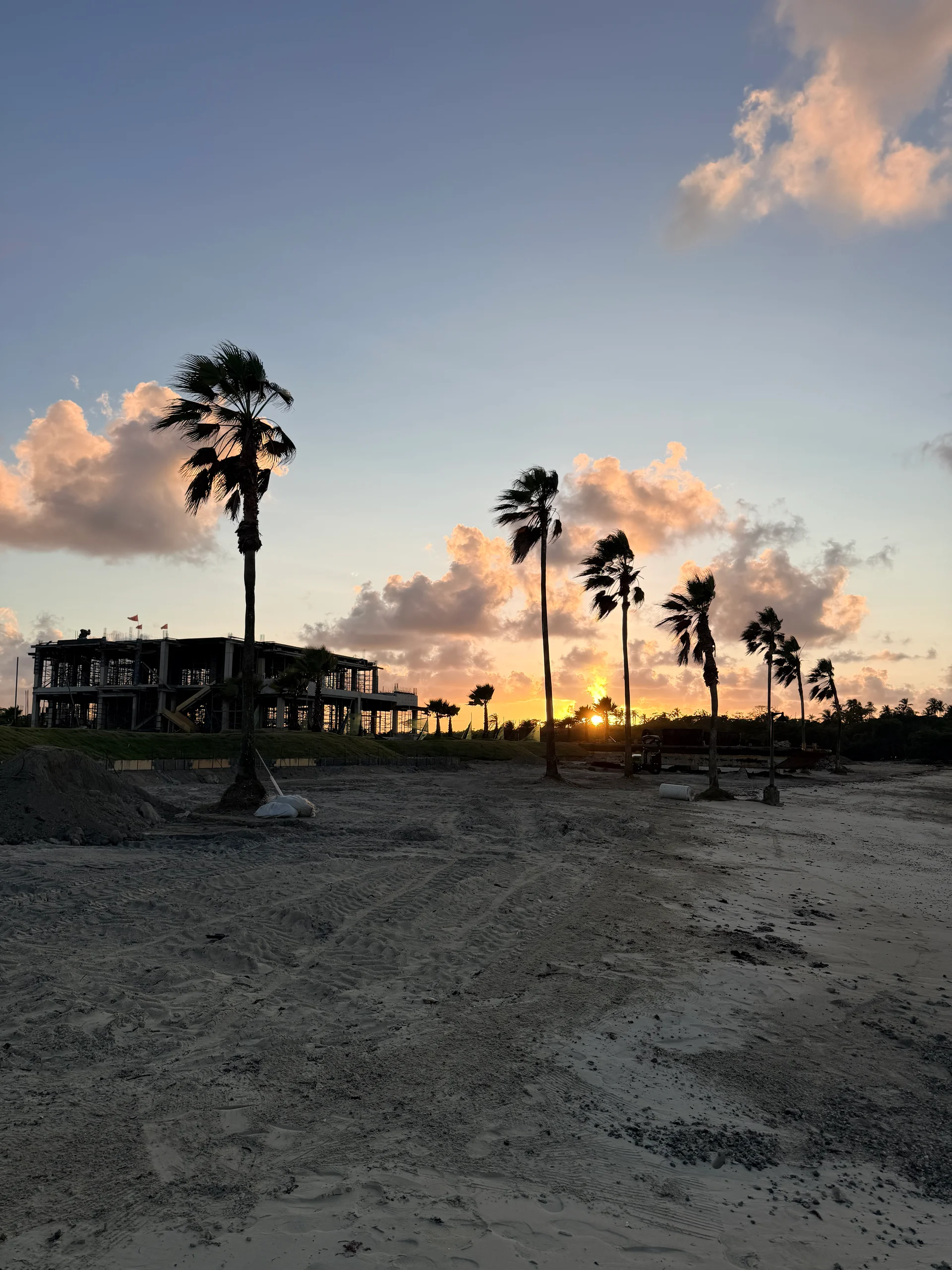 Une vue imprenable au coucher du soleil d'un complexe hôtelier en bord de mer à Panama, mettant en valeur des palmiers se profilant sur un ciel éclatant et l'architecture du complexe. La scène paisible évoque un sentiment de paradis tropical et de détente.